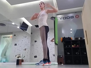 Cute blonde teen doing warmup at the gym